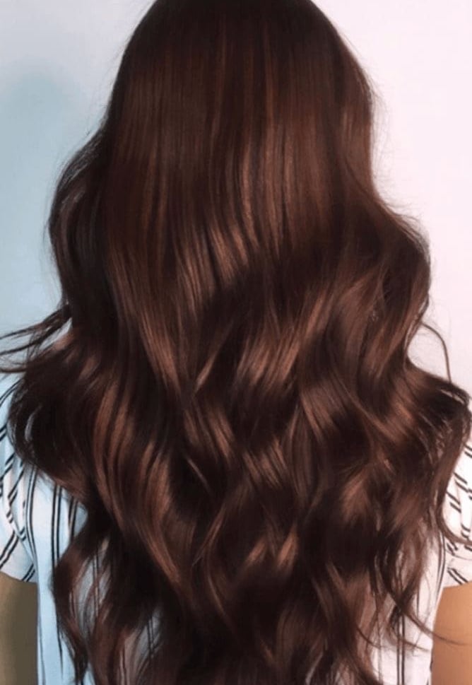 Vista trasera de cabello largo y ondulado color caoba con reflejos chocolate y acabado brillante.