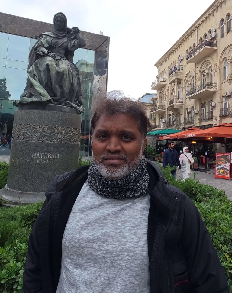 a man standing in front of a statue of a man