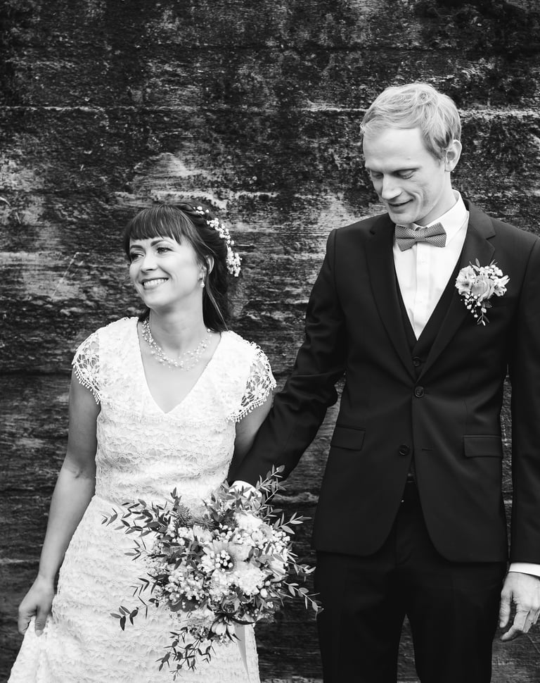 a bride and groom holding hands and smiling