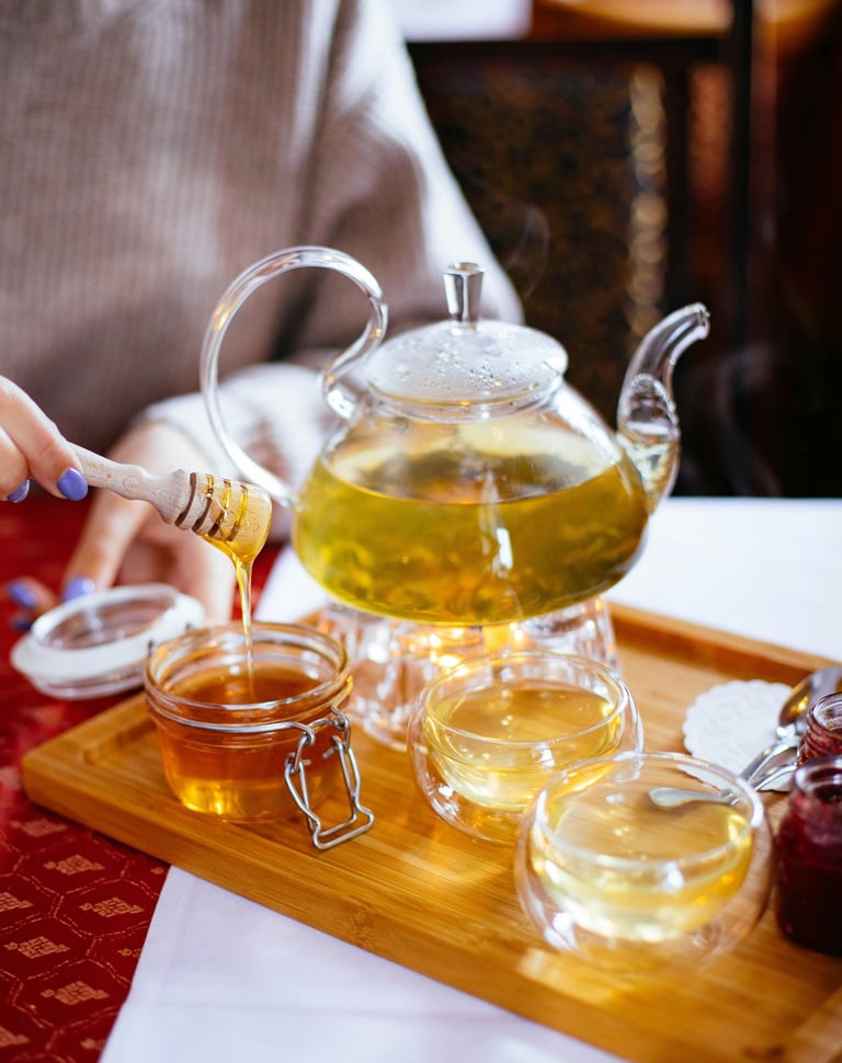 a person pouring tea into a teapot