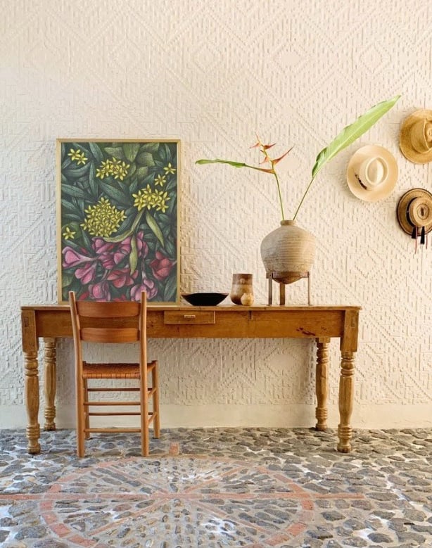Rustic home interior with a wooden table and a chair and a botanical hand-drawn framed art print
