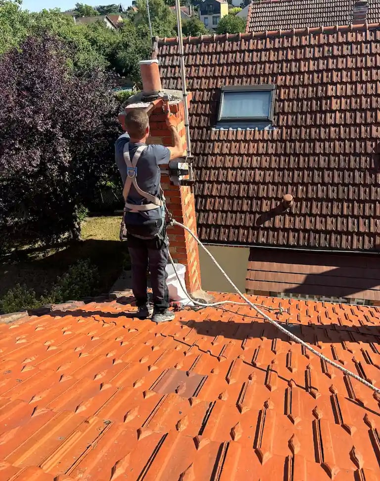 Artisan couvreur MF Couverture en intervention sécurisée pour réparation de cheminée à Montmorency.