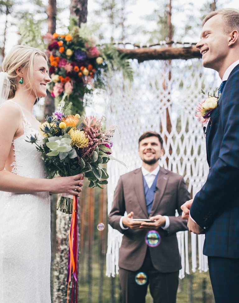 a bride and groom are getting married in a forest