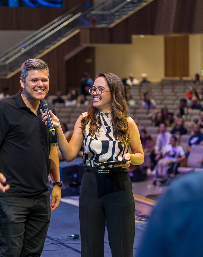 um homem e uma mulher em pé na frente de um microfone