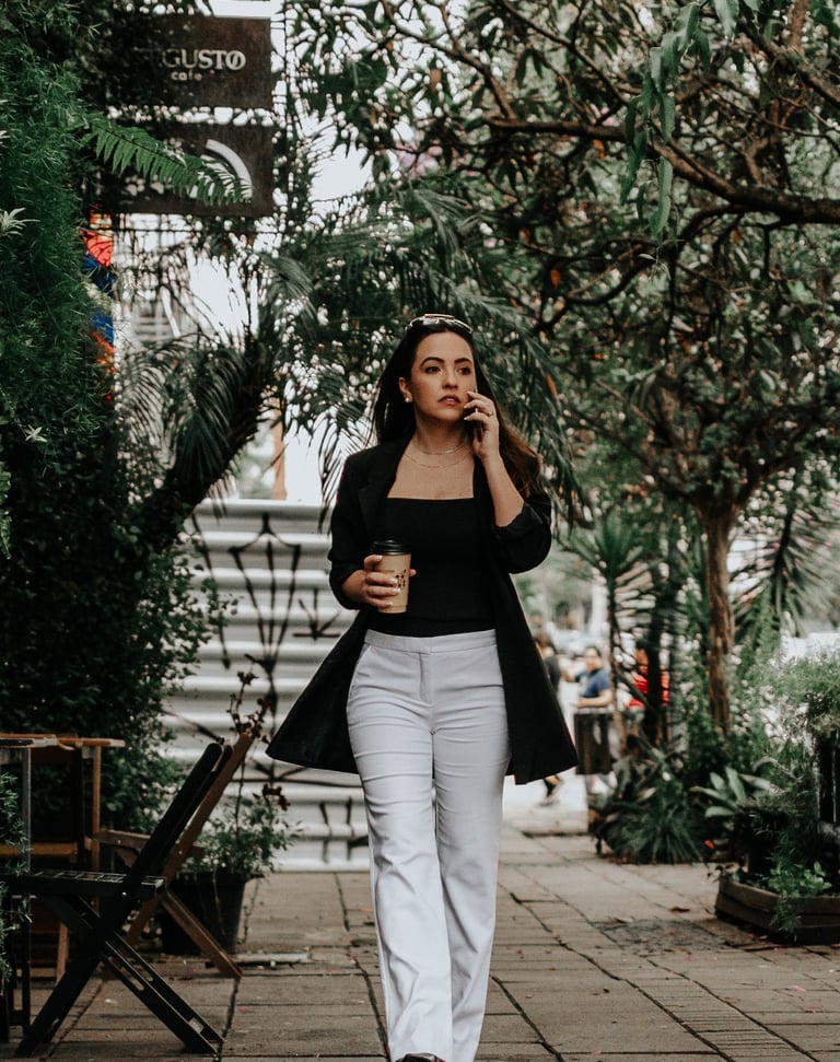 uma mulher caminhando pela calçada com uma xícara de café