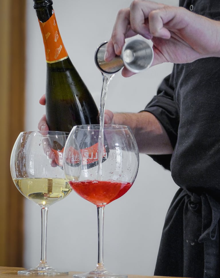 a person pouring wine into wine glasses