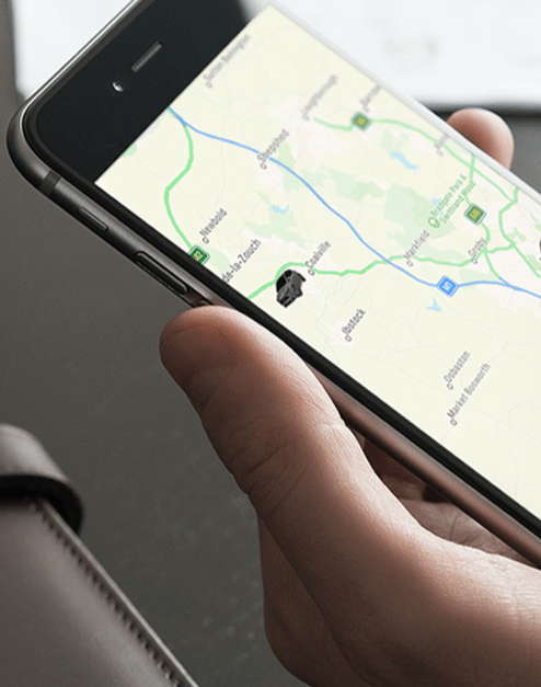 SmarTrack vehicle tracking app on smartphone showing live location map.