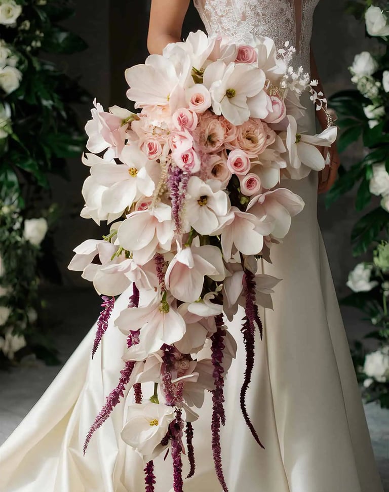 a bridesmael in a white wedding dress with a bouquet of flowers