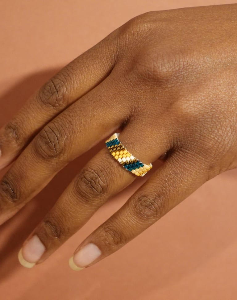 a woman's hand with a ring on her finger handmade with Miyuki beads