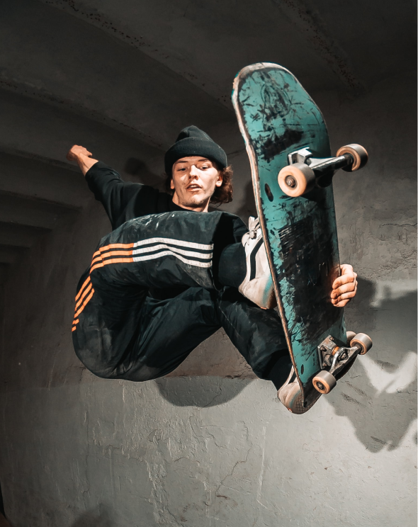 a man in a black shirt is doing a trick on a skateboard