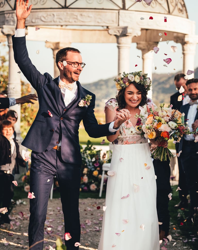 mariés heureux sous pluie de pétales