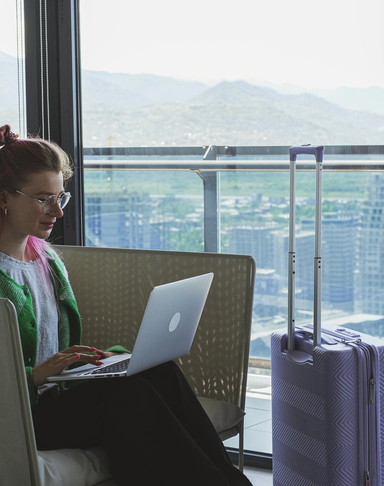 Two women on a rooftop balcony with city views, one holding a cocktail, enjoying a celebration with flowers and drinks.