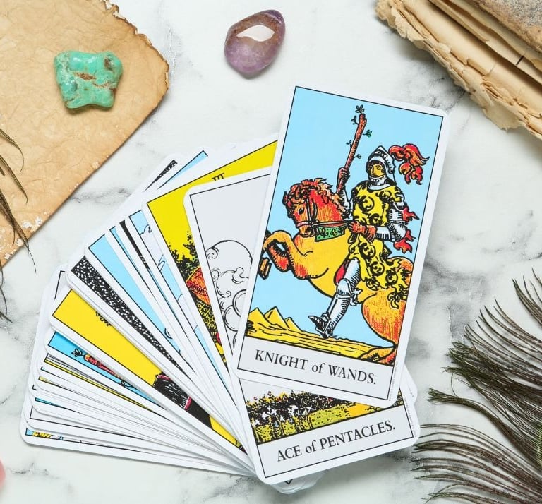 Tarot card stack with the Knight of Wands on top for tarot study and reading.