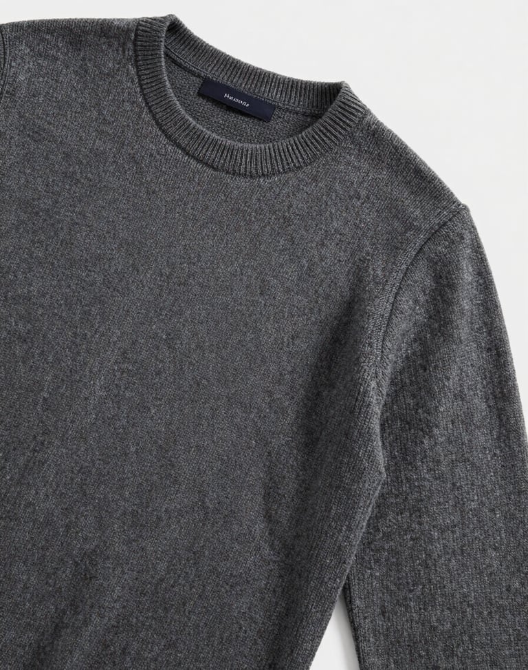 Editorial flat-lay of men's fine-gauge merino wool sweater in charcoal, soft natural light