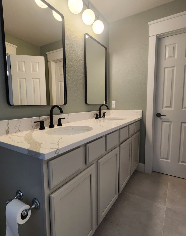 Modern bathroom interior transformation showcasing freshly painted cabinets and soft sage green wall