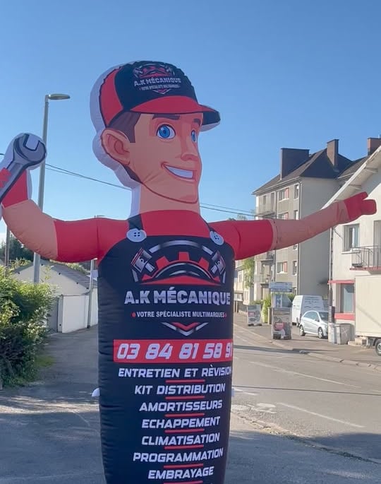a man in a red and black suit and a large inflatable sign