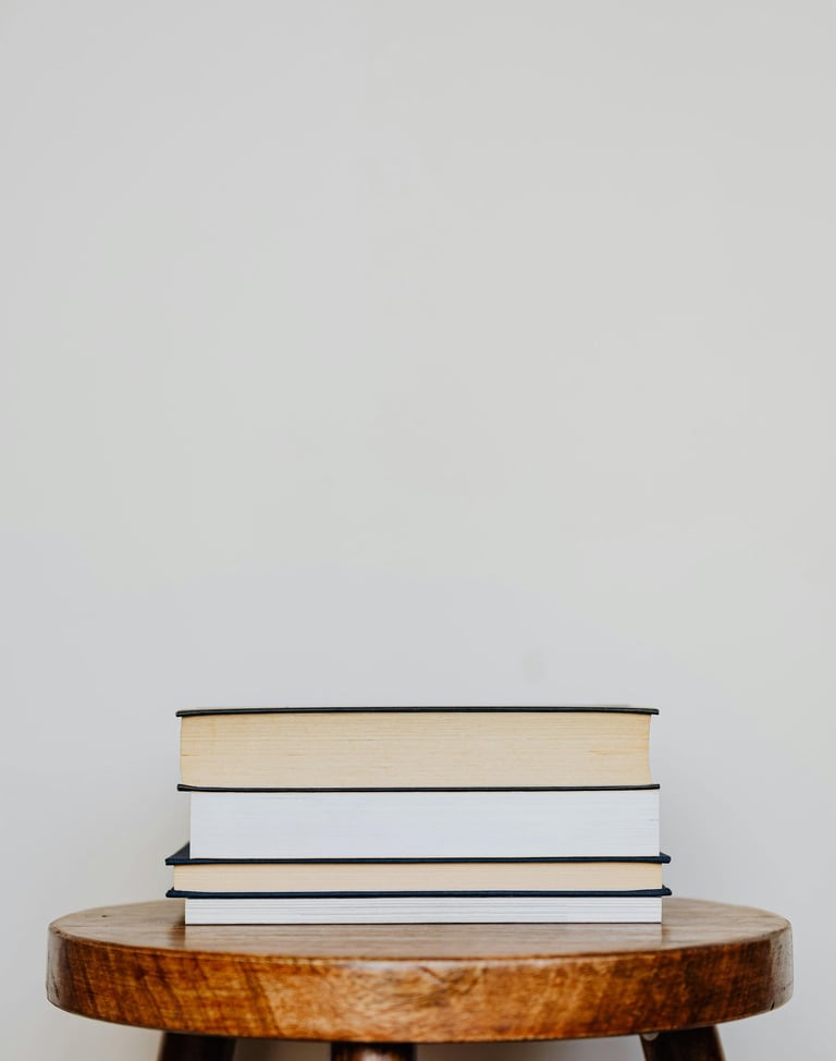 wooden stool with a pile of books on top