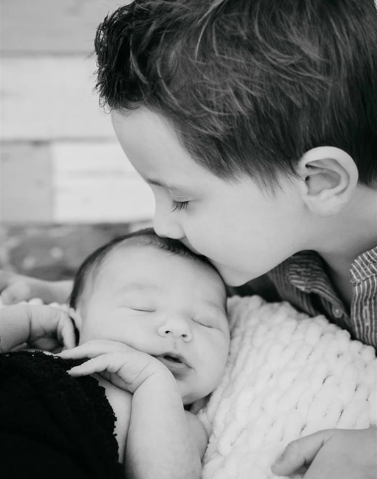 rand frère embrassant bébé sur le front – photo noir et blanc, naissance Gard