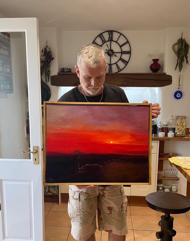 The Artist Chris Gill, holding his painting of Wallabrook Clapper Bridge at Sunset