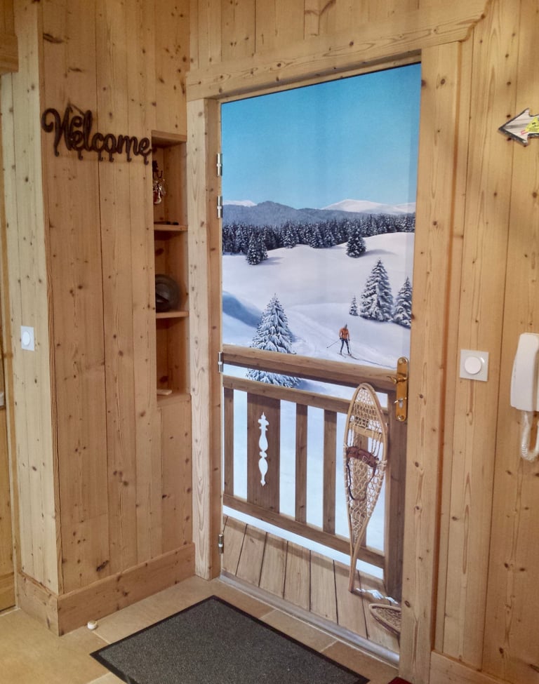Hall d'entrée avec trompe-l'oeil sur porte d'entrée. Paysage neige, skieur, raquettes neige, bois