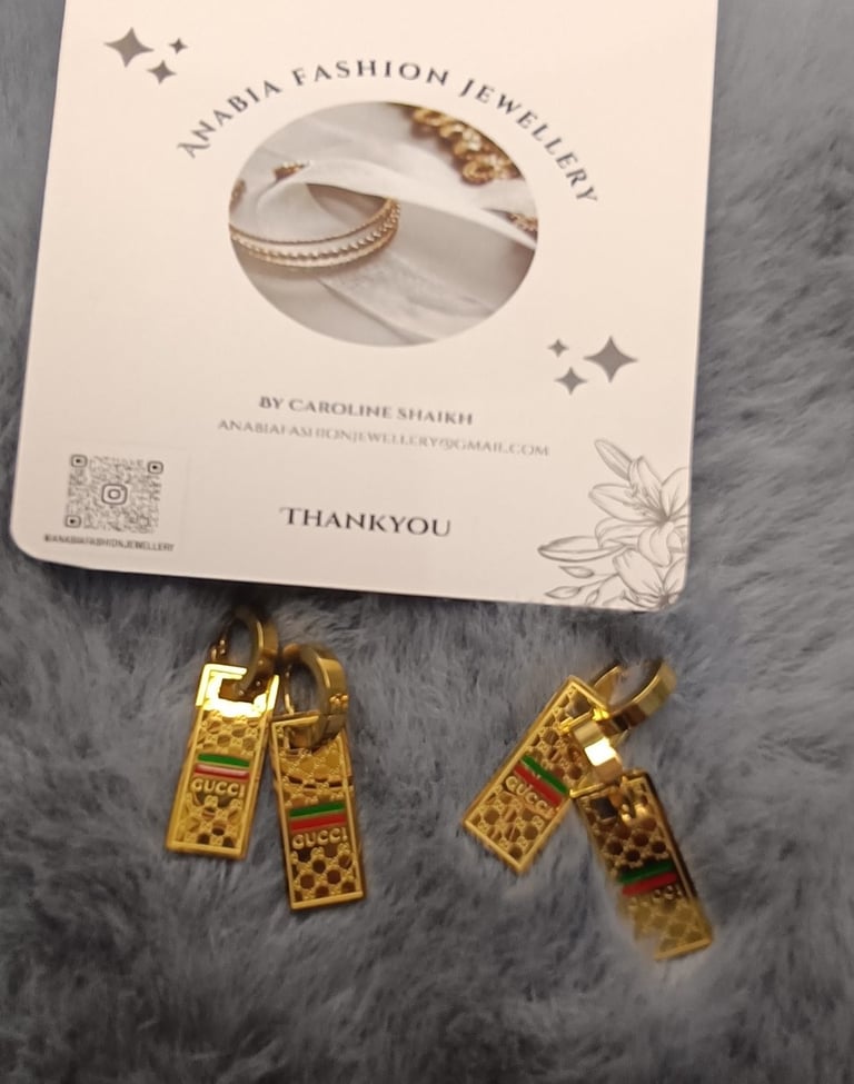 a pair of earrings with gold and silver
