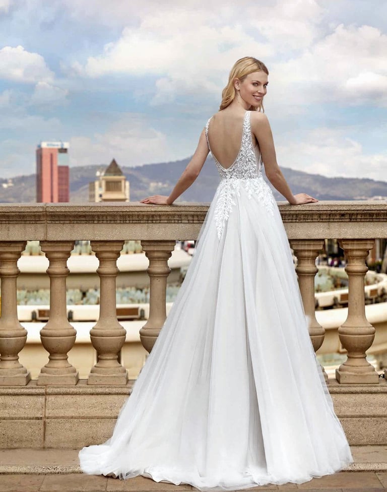 a woman in a white dress standing on a balcony