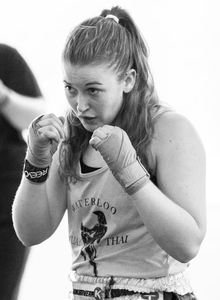 Jessica wearing handwraps with her hands up in a fighting position.