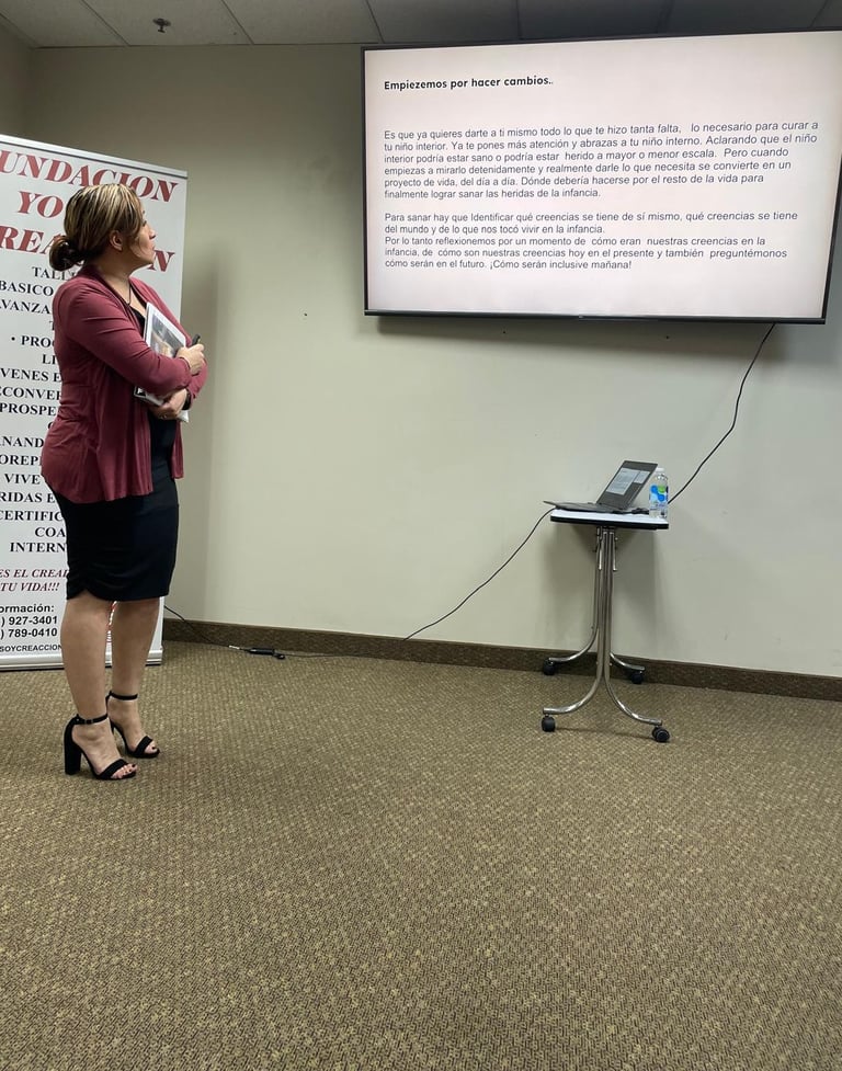 a woman in a red jacket standing in front of a presentation screen