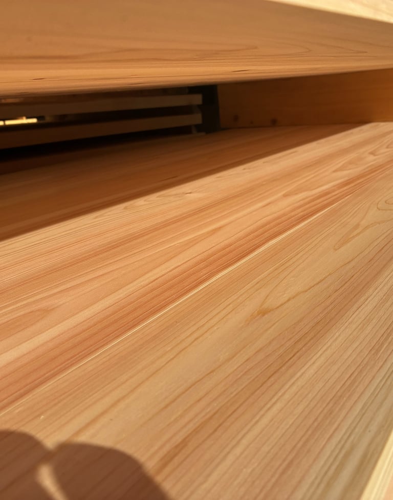 Close-up of smooth, light-colored cypress wood planks stacked at a lumber yard.