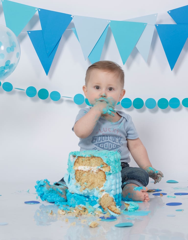 a baby boy in a blue birthday cake
