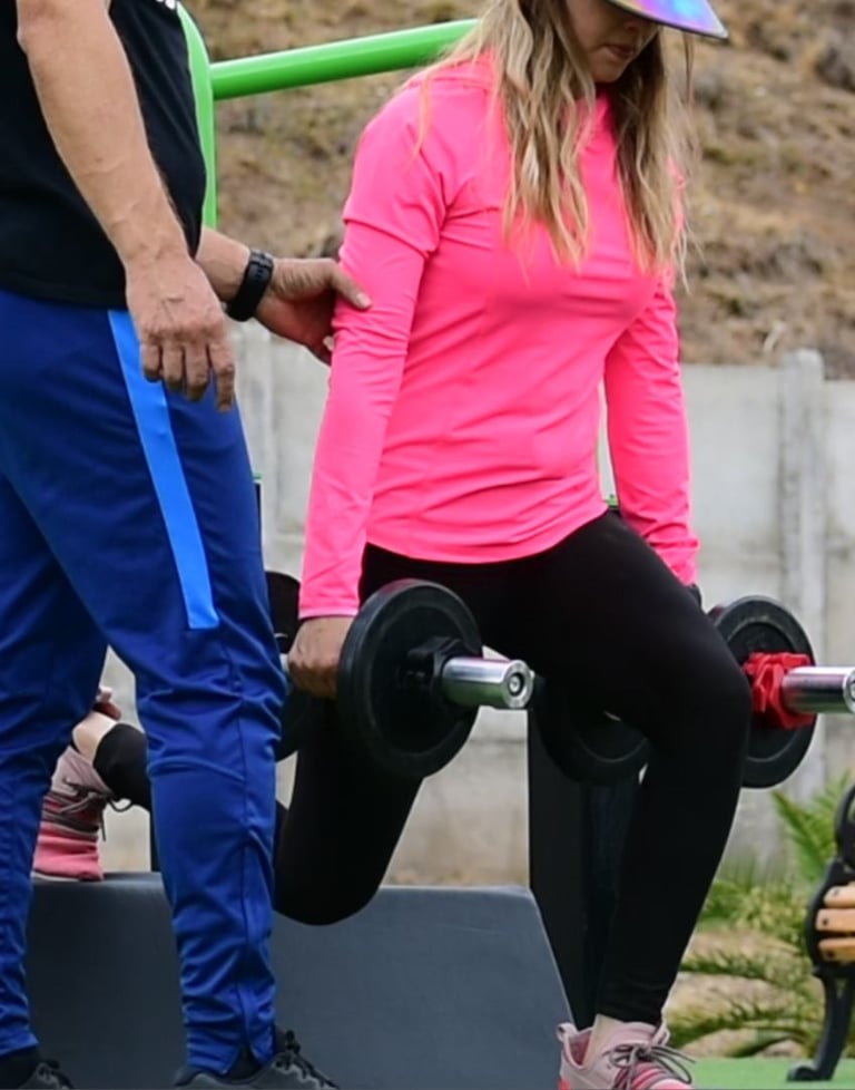 Clienta en sentadillas búlgaras con su personal trainer a domicilio en Vitacura.