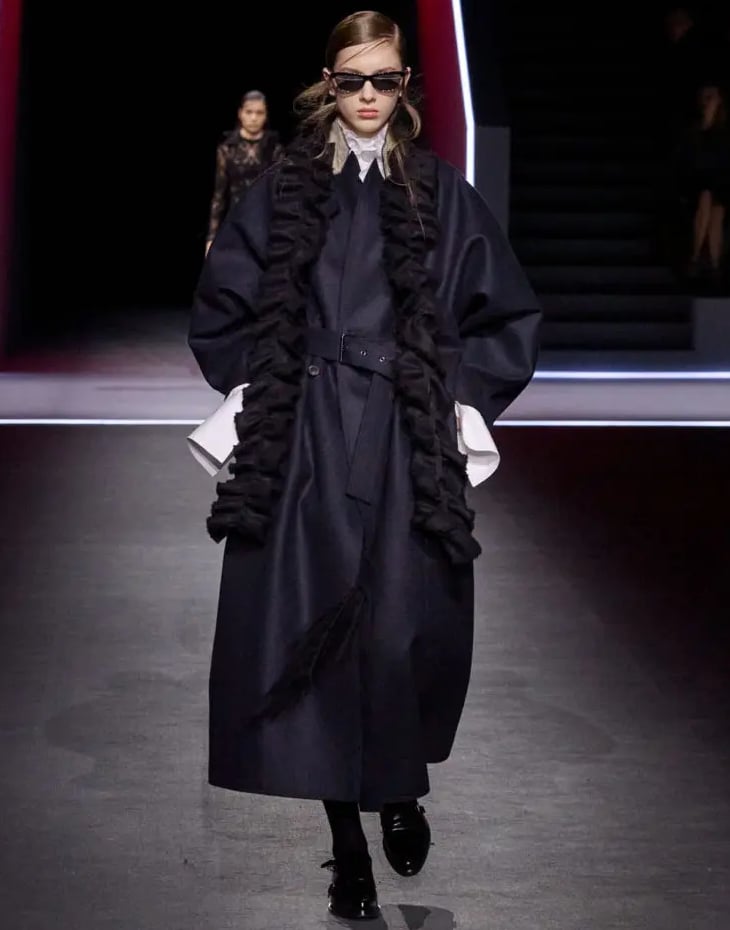 Navy coat with ruffled scarf at Dior FW25 show.