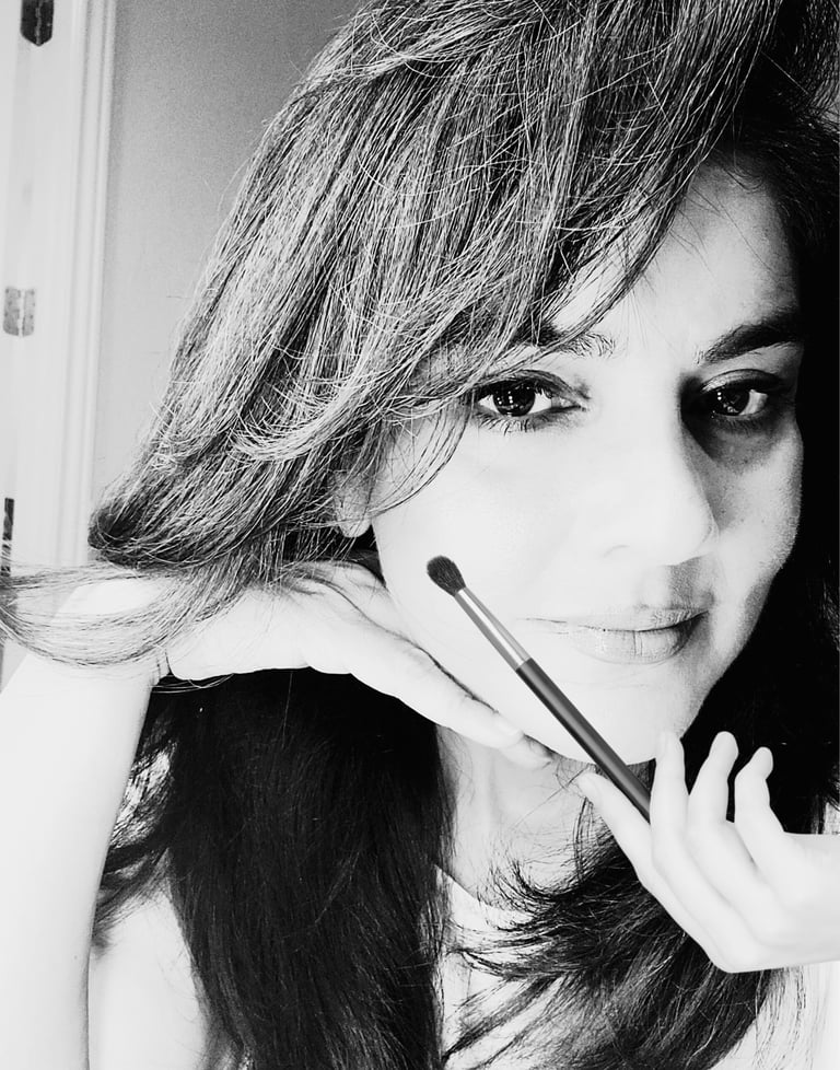 Shazia Ittiq, licensed permanent makeup artist in Oklahoma City, smiling at her desk