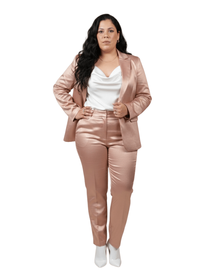 Professional woman in a shimmering rose gold satin blazer and trousers suit with a white cowl neck top.