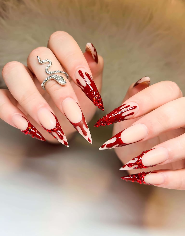 Stiletto fall nails with red blood-drip design and red crystal accents.