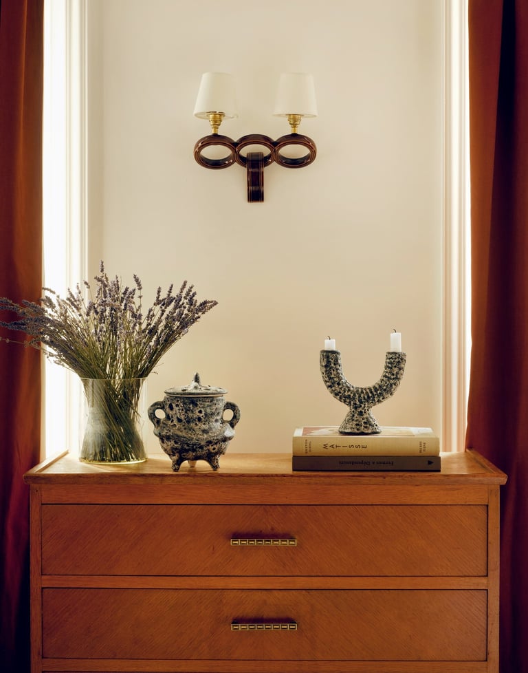 Commode vintage avec céramiques et luminaires chinés, moulures haussmanniennes et rideaux colorés