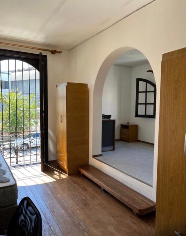 Habitación con escritorio mesa de luz y ventana