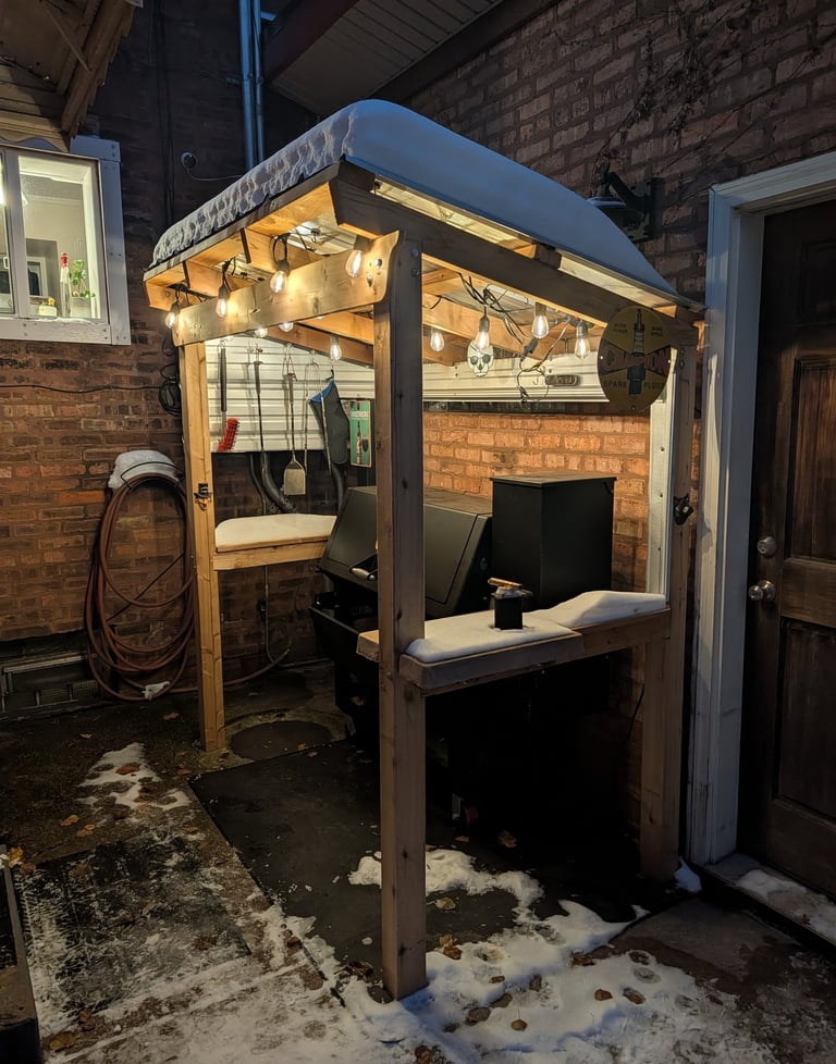 Smoker Shelter sheltering smoker from snow and fully lit. December 2025