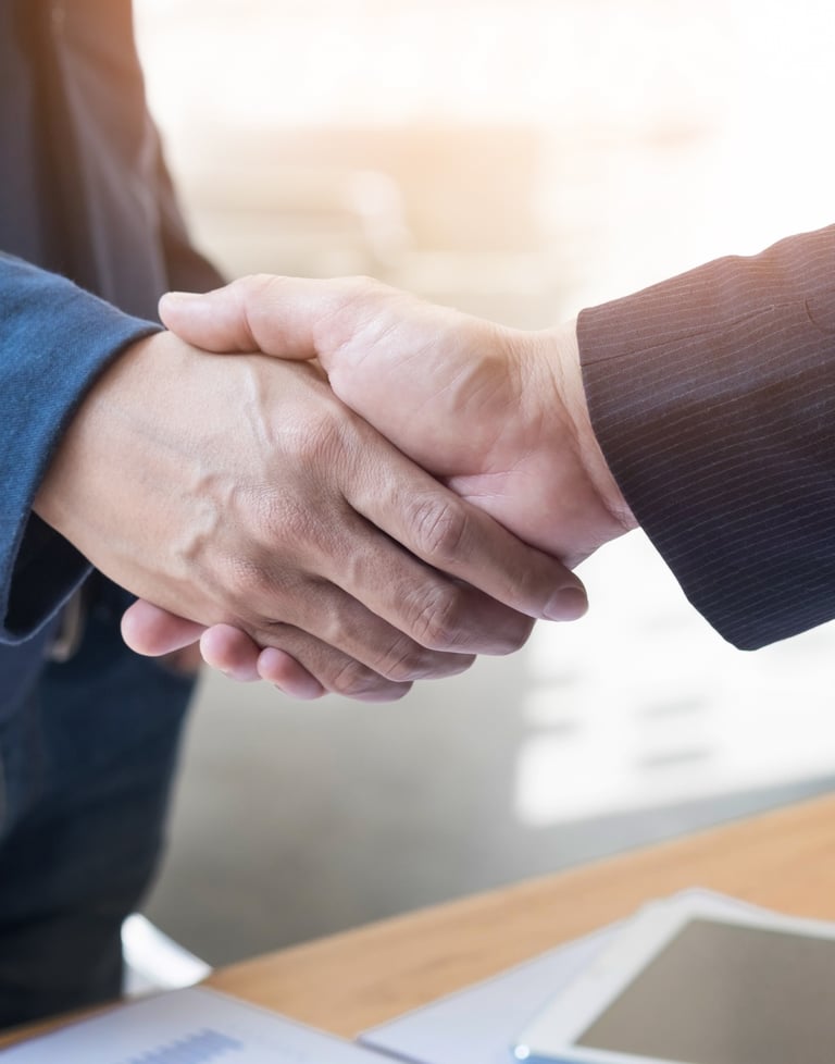 two people shaking hands with a laptop