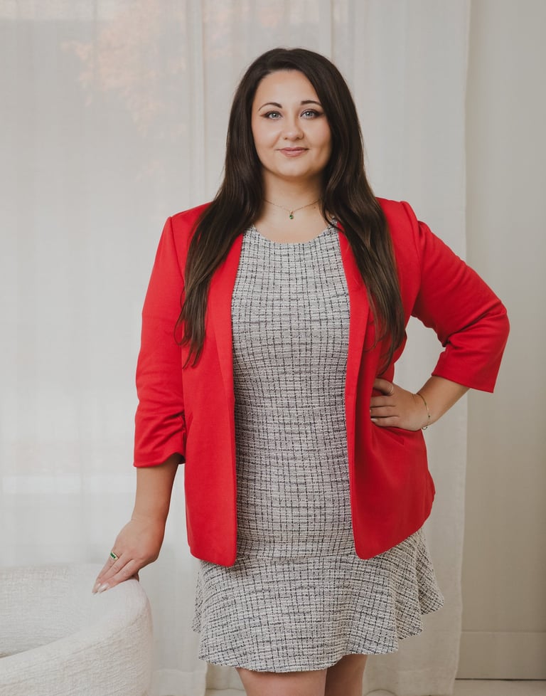 Adriana portrait of a brunette businesswoman in a red blazer and tweed dress.