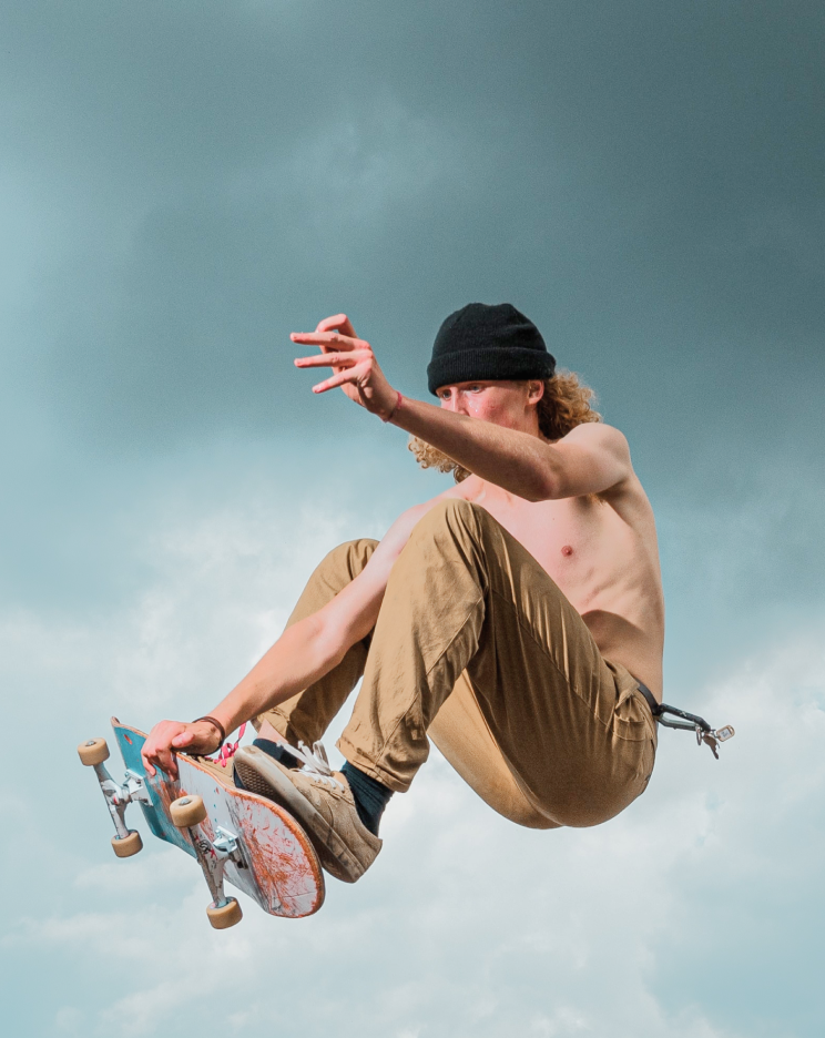 a man in a black hat and a skateboarder in mid air