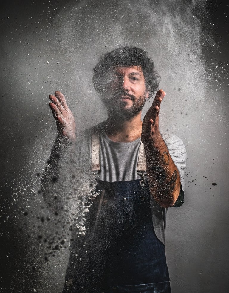 a chef wearing a apron throwing floor in the air