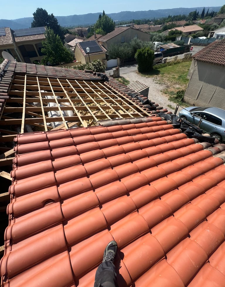 Remise en état de la toiture avec des tuiles avant la pose des nouveaux panneaux en surimposition.