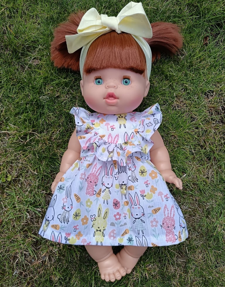 Minikane doll Gabrielle dressed in a ruffled dress with a bow headband
