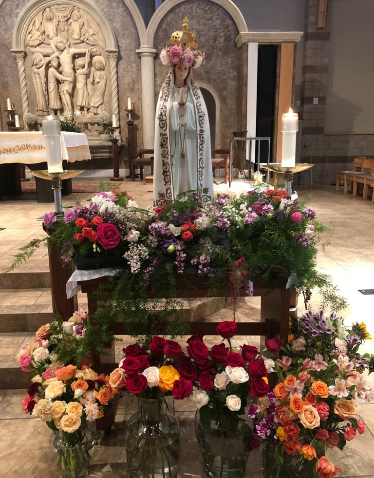 Our Blessed Mother at May Crowning surrounded by flowers