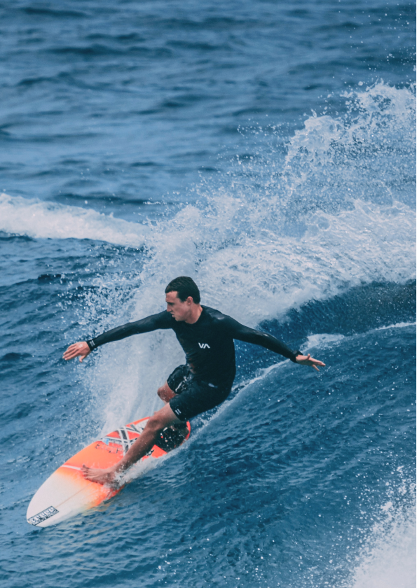 a man in a wetsuit surfing on a surfboard