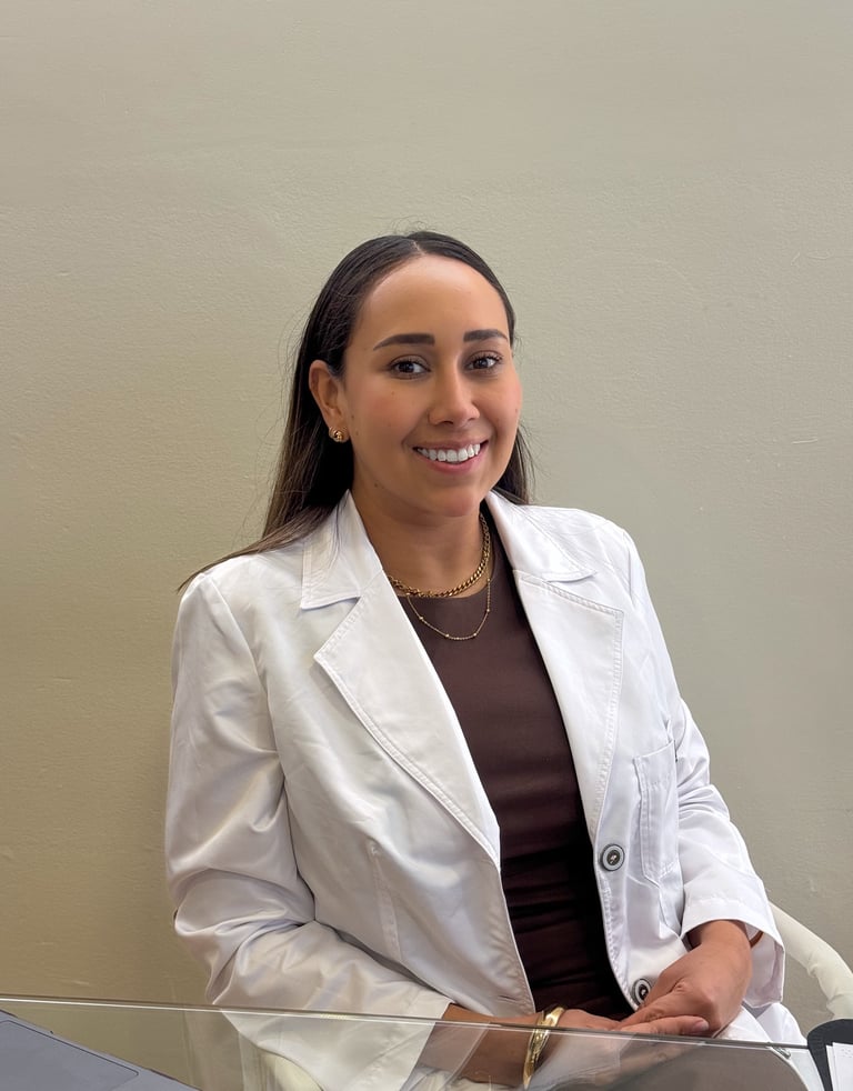 Dra Brenda Ortiz especialista en medicina estetica sentada en un escritorio