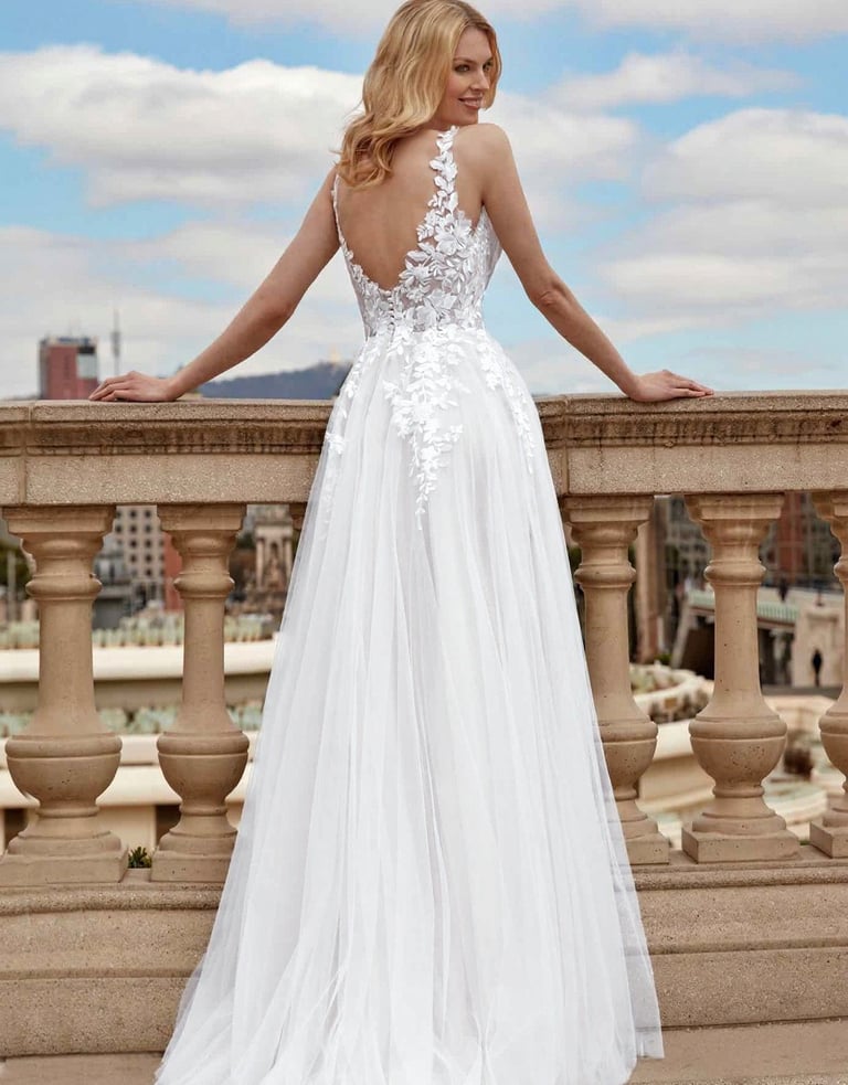 a woman in a white dress standing on a balcony
