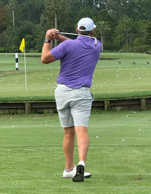 Men’s performance golf polo in purple on golf course