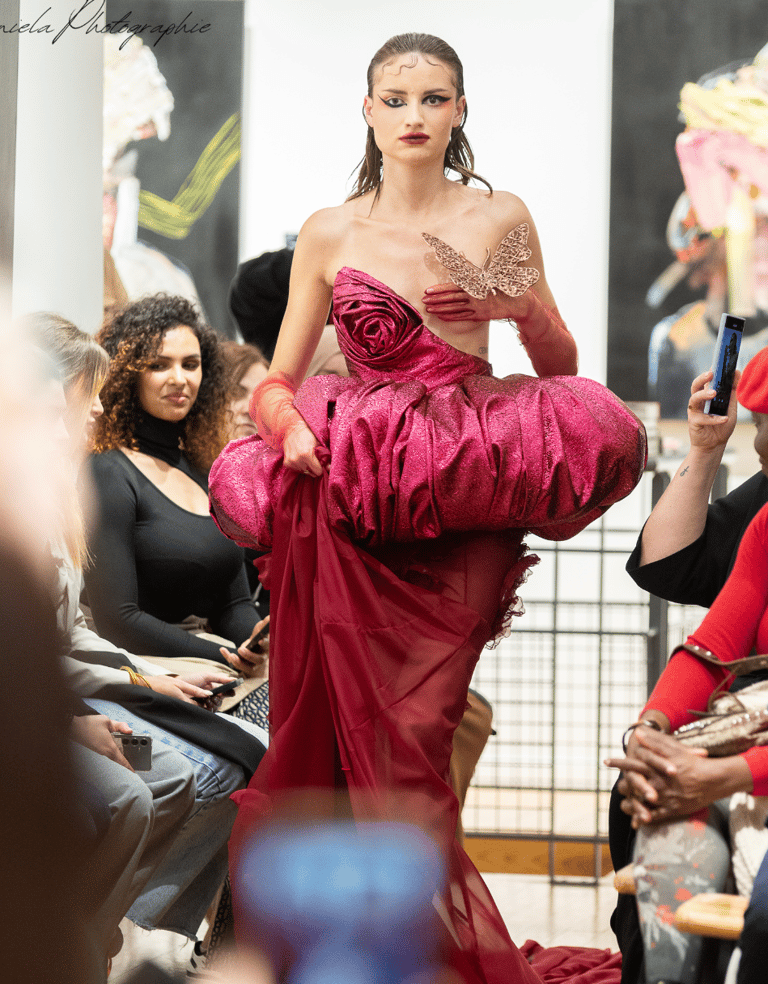 a woman in a red dress is walking down the runway